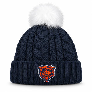 A navy blue cable-knit beanie with a fluffy white pom-pom on top and an embroidered Chicago Bears logo on the front cuff.