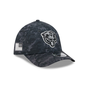 A dark digital camouflage baseball cap featuring a white embroidered Chicago Bears bear head logo on the front and a black-and-white American flag patch on the side.