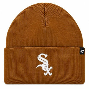 A ribbed knit beanie hat in a warm brownish-orange color, featuring a white embroidered Chicago White Sox logo on the front cuff and a small black '47 brand tag on the right side of the cuff.