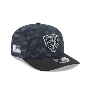 A dark digital camouflage baseball cap with a black visor, featuring a white embroidered Chicago Bears bear head logo on the front and a black-and-white American flag patch on the side.