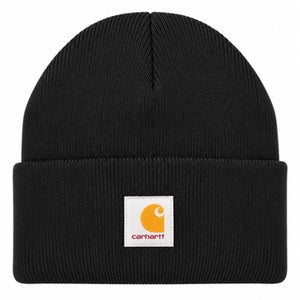 A black ribbed knit beanie hat with a folded cuff, featuring a square white Carhartt logo patch on the front.